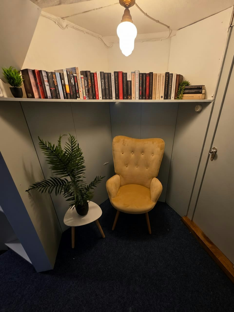 Das Federstübchen mit gelbem Sessel und Bücherregal